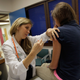 A pediatrician gives an HPV vaccination to a 13-year-old girl.